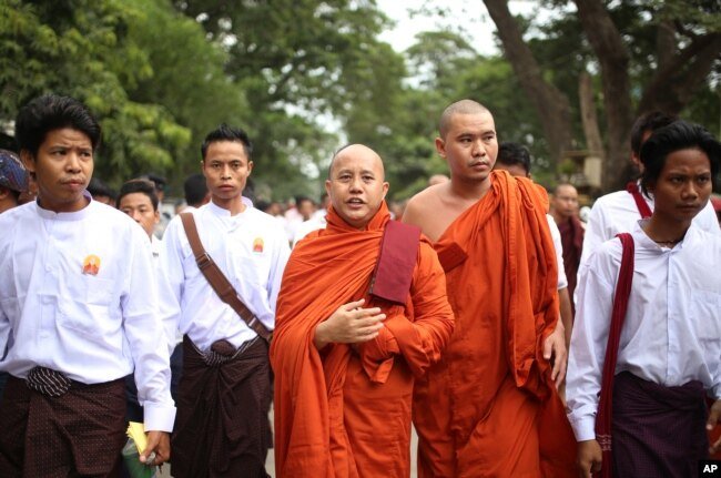 Nationalist Buddhist monk Wirathu, center, marches to celebrate newly imposed restrictions on interfaith marriages in Mandalay, the second largest city in Myanmar, Sept. 21, 2015.