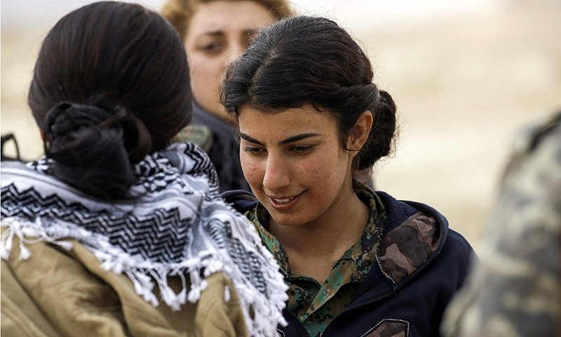 Doza Jiyan, a 21-year-old female Arab fighter in the SDF, talks to other fighters. ─AFP