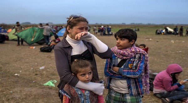 A migrant from Syria cries as she stands with her children on a field after crossing into Hungary from the border with Serbia near the village of Roszke, September 5, 2015. Austria and Germany threw open their borders to thousands of exhausted migrants on Saturday, bussed to the Hungarian border by a right-wing government that had tried to stop them but was overwhelmed by the sheer numbers reaching Europe's frontiers. REUTERS/Marko Djurica