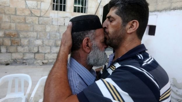 Man kisses the father of Mohammed Allan, following news that his detention has been suspended - 19 August