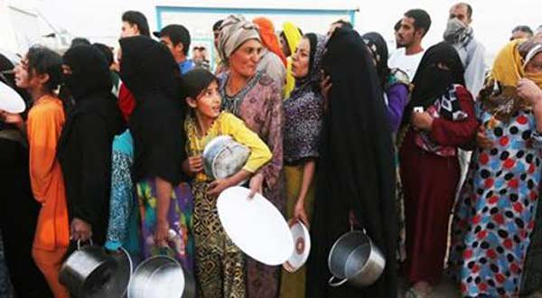 Iraqi families displaced by violence queue up for food.
