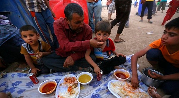 Iraqi refugees, who fled the violence in Mosul, eat their Iftar, the breaking of fast, meal during the holy fasting month of Ramadan inside a refugee camp on the outskirts of Arbil, in Iraq’s Kurdistan region, June 29, 2014. Reuters