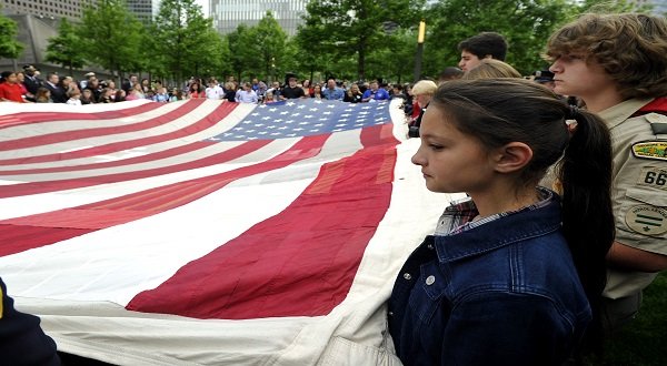 Children hold the 9/11 Flag in front of the National September 11 Memorial Museum in New York, on May 21, 2014. The memorial museum  opened to the general public after a ceremonial transfer of the National 9/11 Flag. Xinhua/Wang Lei/IANS