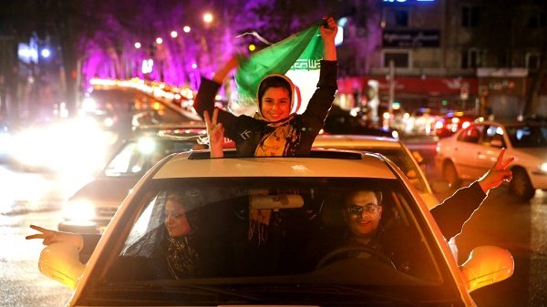 Iranians celebrate the nuclear agreement with world powers, on a street in northern Tehran. Image credit: AP