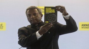 Secretary General of Amnesty International, Salil Shetty, shows the 2016/2017 Amnesty International report during a press conference, in Paris, Tuesday. -- AP