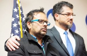 Farhan Khan, left, brother-in-law of one of the suspects involved in a shooting in San Bernardino, Calif., is held by Hussam Ayloush, executive director of Council on American-Islamic Relations, during a news conference at the Greater Los Angeles Area office of the Council on American-Islamic Relations, in Anaheim, Calif. — AP