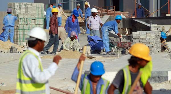 Foreign workers lay an entrance road at the construction site of a new hotel in the new City Center and West Bay district in Doha, Qatar. Photo by Sean Gallup/Getty Images