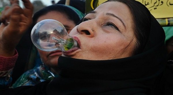 An activist holds a light bulb in her mouth during a rally in Lahore, against widespread electricity shortages in the country. AFP file.