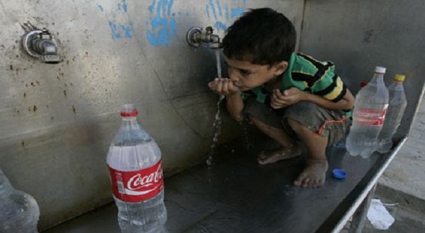LIFE UNDER SIEGE...A Palestinian boy drinks water from a public tap at the United Nations Relief and Works Agency headquarters in the southern Gaza Strip Rafah refugee camp. Photograph: Said Khatib/AFP/Getty Images