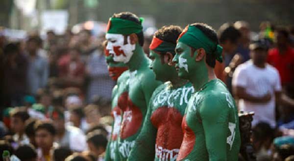 Three men stand in Bangladeshi national colours in Shahbag square. Photograph: Kazi Sudipto/ Demotix/Corbis