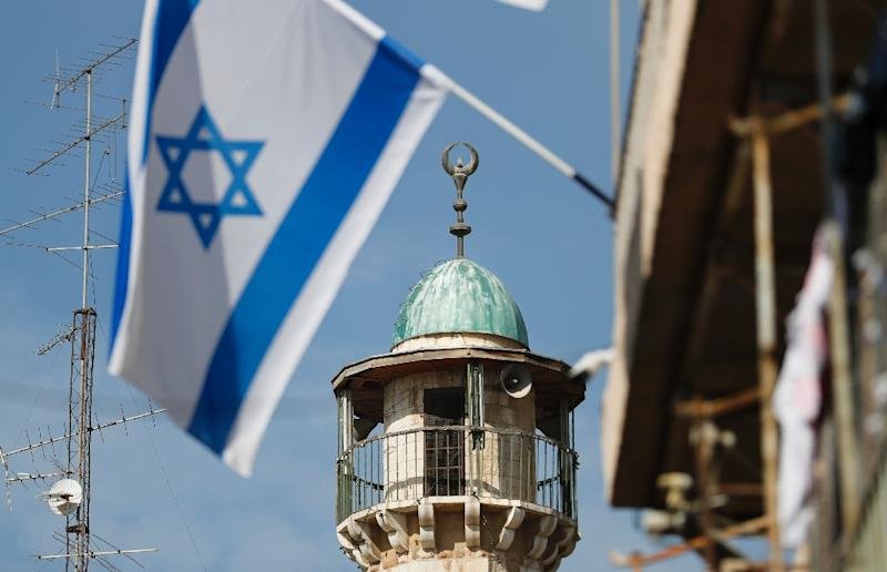 An Israeli flag waves in front of the minaret of a mosque in the Arab quarter of Jerusalem&#39;s Old City