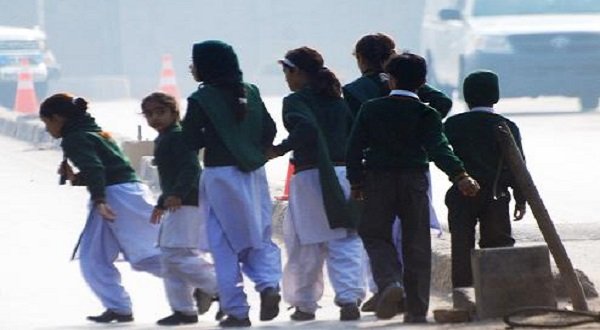 Schoolchildren cross a road as they move away from a military run school that is under attack by Taliban gunmen in Peshawar, December 16, 2014. REUTERS/Khuram Parvez
