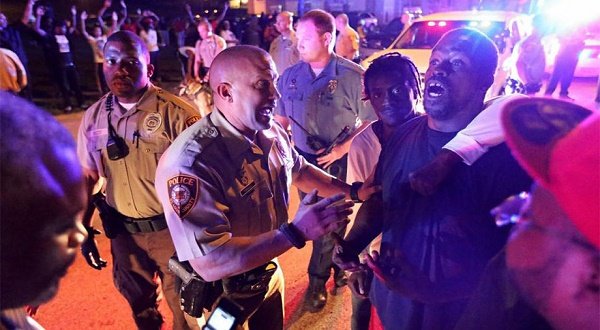 Angry Ferguson residents confront police on August 9, the day of the shooting of a black man by police.