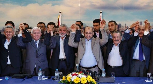 Senior Fatah and Hamas officials hold their hands after announcing a reconciliation agreement in Gaza City April 23, 2014. Photo by Reuters
