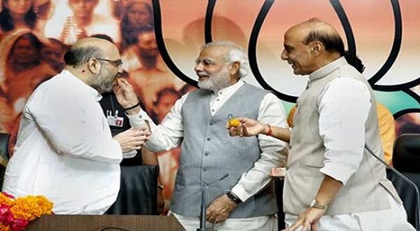 Prime Minister Narendra Modi congratulates Amit Shah at a press conference in New Delhi where an announcement on his appointment as BJP chief was made
