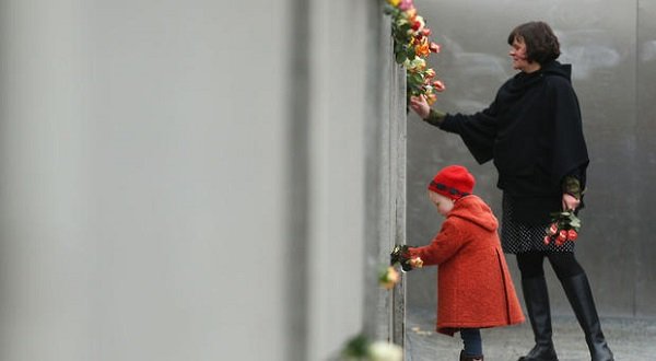 Hulda, 3, places flowers in between slats of the former Berlin Wall at the Berlin Wall Memorial at Bernauer Strasse on the 25th anniversary of the fall of the Wall on November 9, 2014, in Berlin, Germany.  Sean Gallup/Getty Images