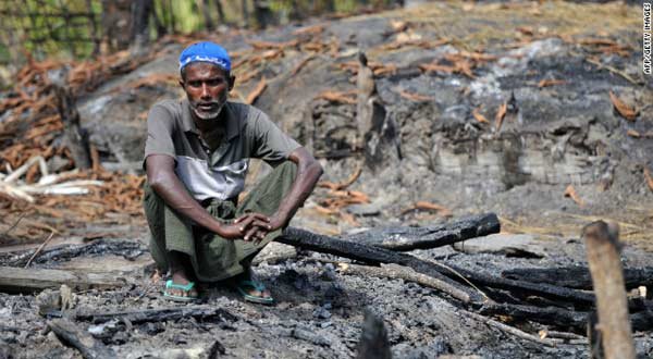 A Rohingya man sits at his burnt home at a village in Minpyar in Rakhine state.