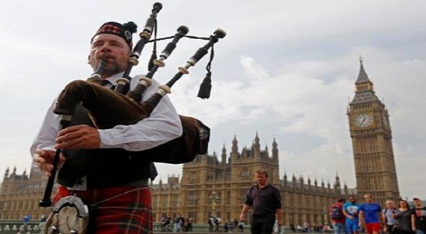 Piper Anton Doherty plays to passers-by in front of the Houses of Parliament on Westminster Bridge in London September 18, 2014.  REUTERS/Luke MacGregor