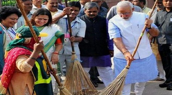 Prime Minister Narendra Modi wields a broom with NDMC workers to launch the “Swachh Bharat Abhiyan” at Valmiki Basti in New Delhi on Thursday. PTI