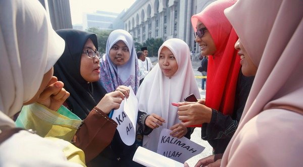 Muslim women gather outside the court after a hearing on the "Allah" court case in Putrajaya outside Kuala Lumpur June 23, 2014. Malaysia's Federal Court on Monday rejected an application for leave by the Catholic Church to challenge a Court of Appeal decision to prohibit the weekly Herald Bahasa Malaysia section from using the word "Allah". Reuters photo.