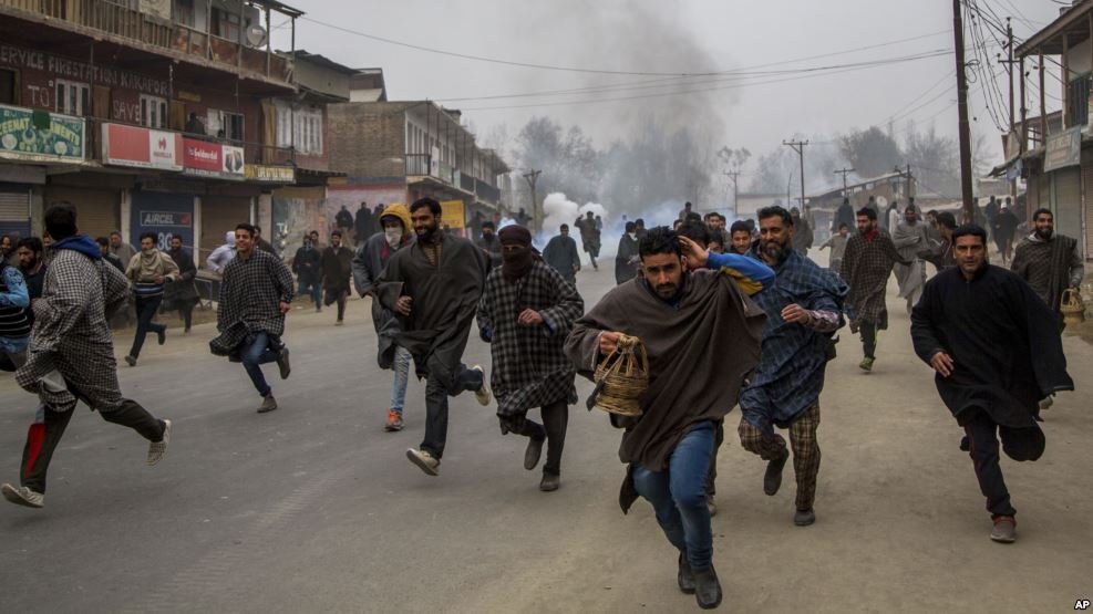 FILE - Kashmiri villagers run for cover from tear gas shells and pellets fired at by Indian police during a protest near the funeral of Rayees Ahmad Dar, a suspected militant of Lashkar-e-Taiba in Kakpora village south of Srinagar, Indian controlled Kashmir.