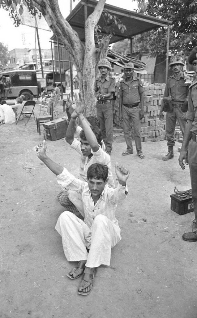 Policemen watch over the 'usual suspects' during the Meerut riots of 1987 in Uttar Pradesh. Image source: Praveen Jain